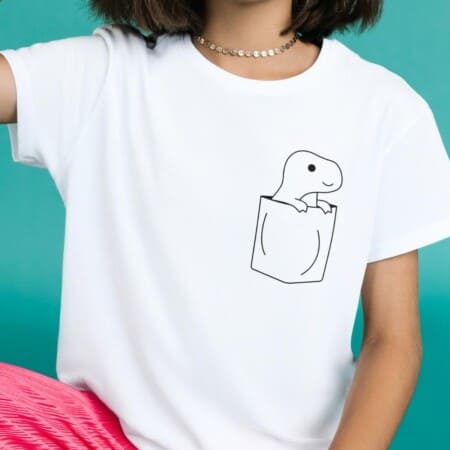 a woman wearing a t - shirt with a picture of a dinosaur in a pocket.