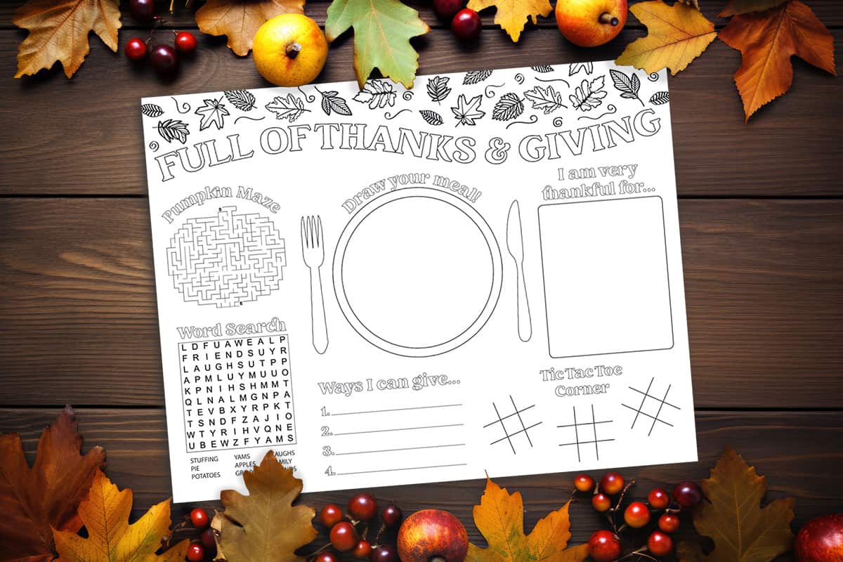 Thanksgiving Activity Placemat free printable on a wood table with leaves and fruit surrounding it.